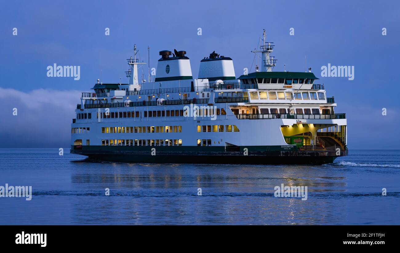 Una navigazione di mattina presto per il nuovo traghetto dei Washington state Ferries Suquamish mentre naviga sulle acque calme di daybreak durante il periodo dell'ora blu Foto Stock