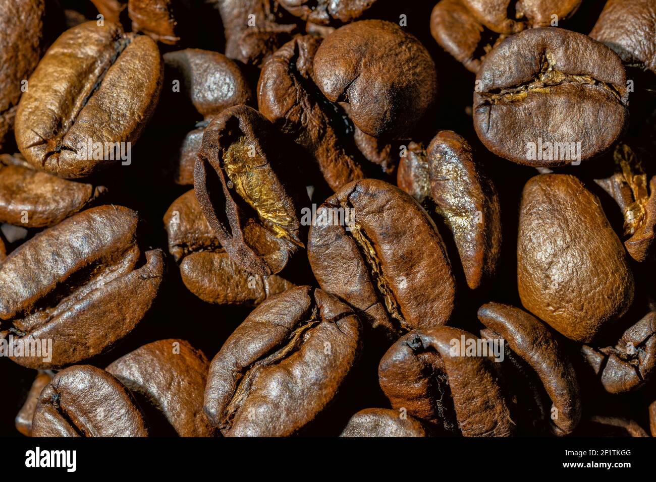 Primo piano di chicchi di caffè. Consistenza di chicchi di caffè, chicchi di caffè tostati marroni. Chicchi di caffè di sfondo dall'alto Foto Stock