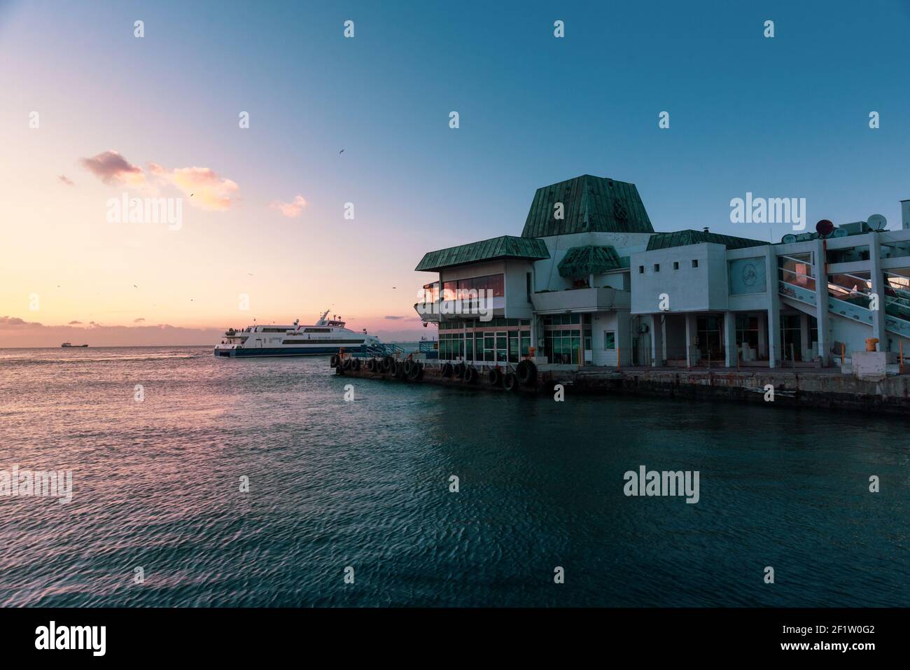 Izmir, Turchia - Gennaio 10 2021, vista serale del traghetto Konak con una barca a vapore e alcuni passeggeri Foto Stock