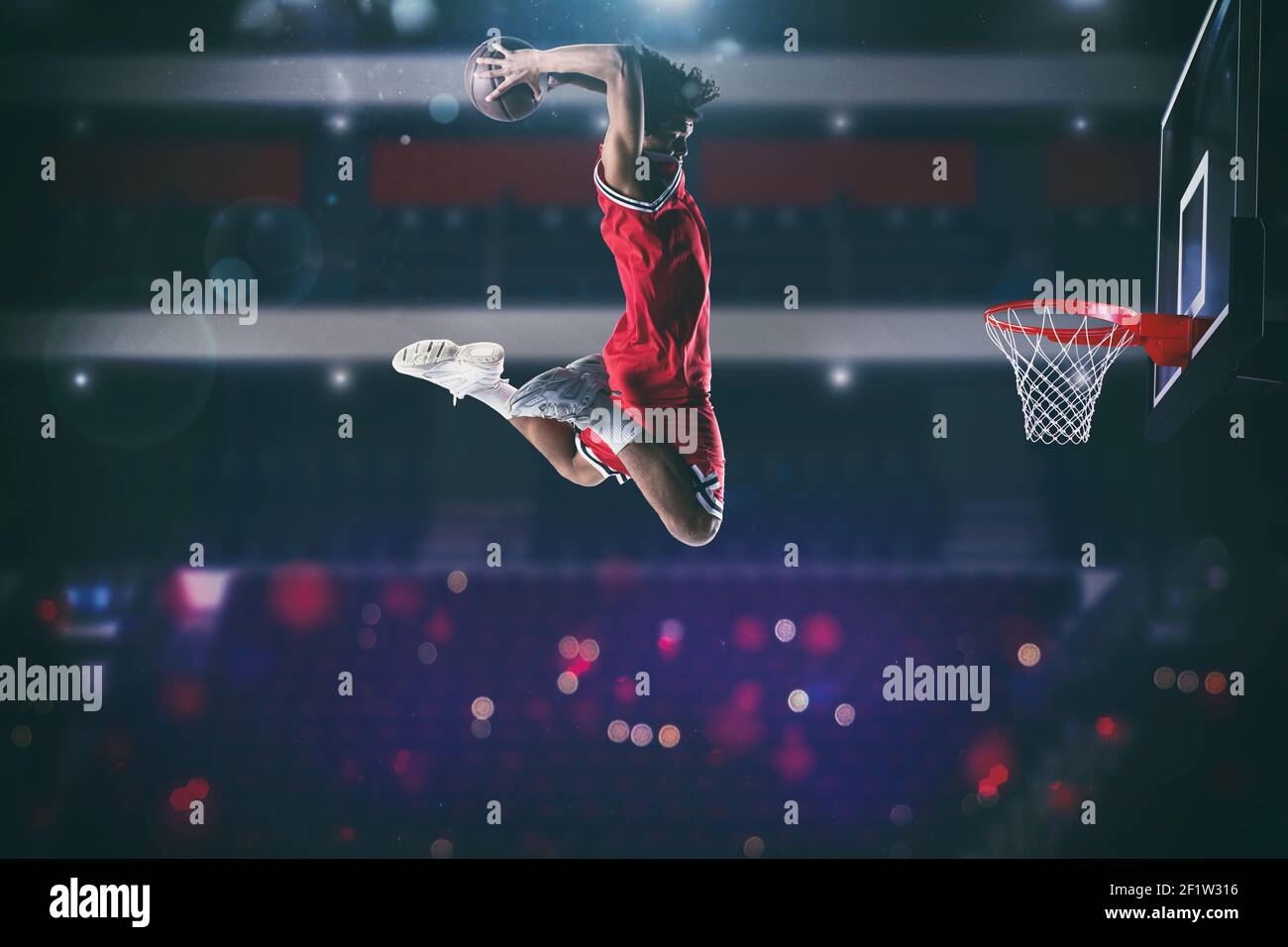 Gioco di pallacanestro con un giocatore di salto alto per fare un slam dunk al cesto Foto Stock