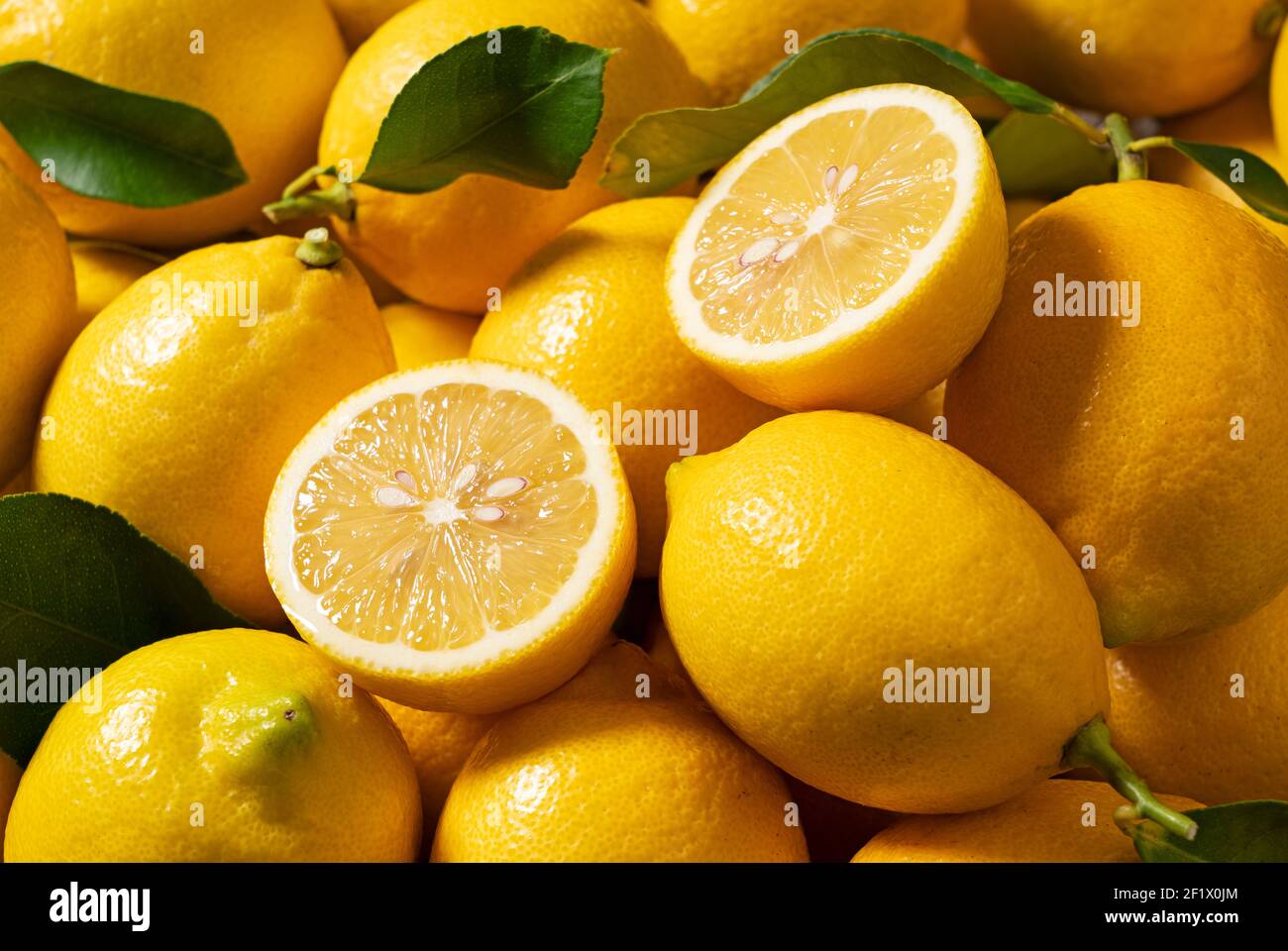 Limoni messi e tagliati su tutto lo schermo. Sfondi di limone Grafica web Foto Stock