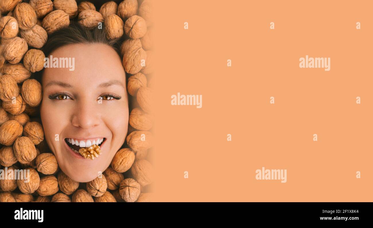 Donna felice faccia con sorriso perfetto su uno sfondo di noci con spazio per la copia Foto Stock
