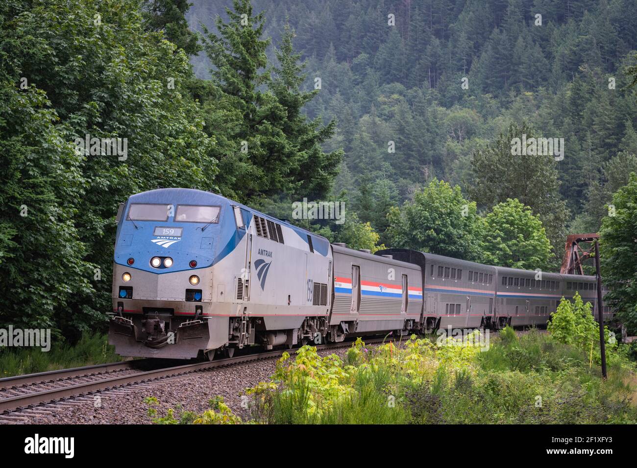 Treno interstatale Amtrak Empire Builder con pernottamento in treno da Seattle a Chicago si avvicina allo Skykomish nello stato di Washington Foto Stock
