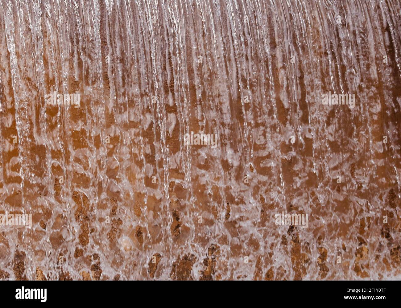 Acqua astratta che cade con sfondo arancione Foto Stock