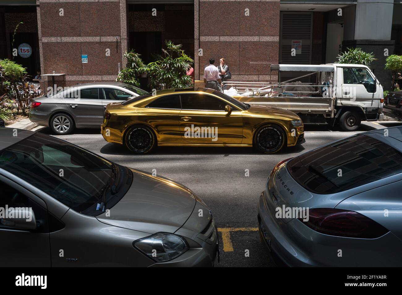 26.03.2018, Singapore, Repubblica di Singapore, Asia - UNA scena di strada con un'auto sportiva che splende come l'oro nel quartiere centrale degli affari. Foto Stock