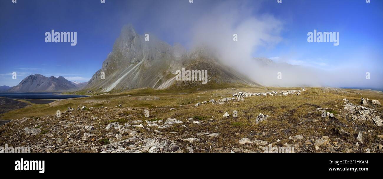 Montagna Eystrahorn con il cielo blu e una nuvola di nebbia, il divario climatico, Islanda orientale, Islanda, Europa Foto Stock