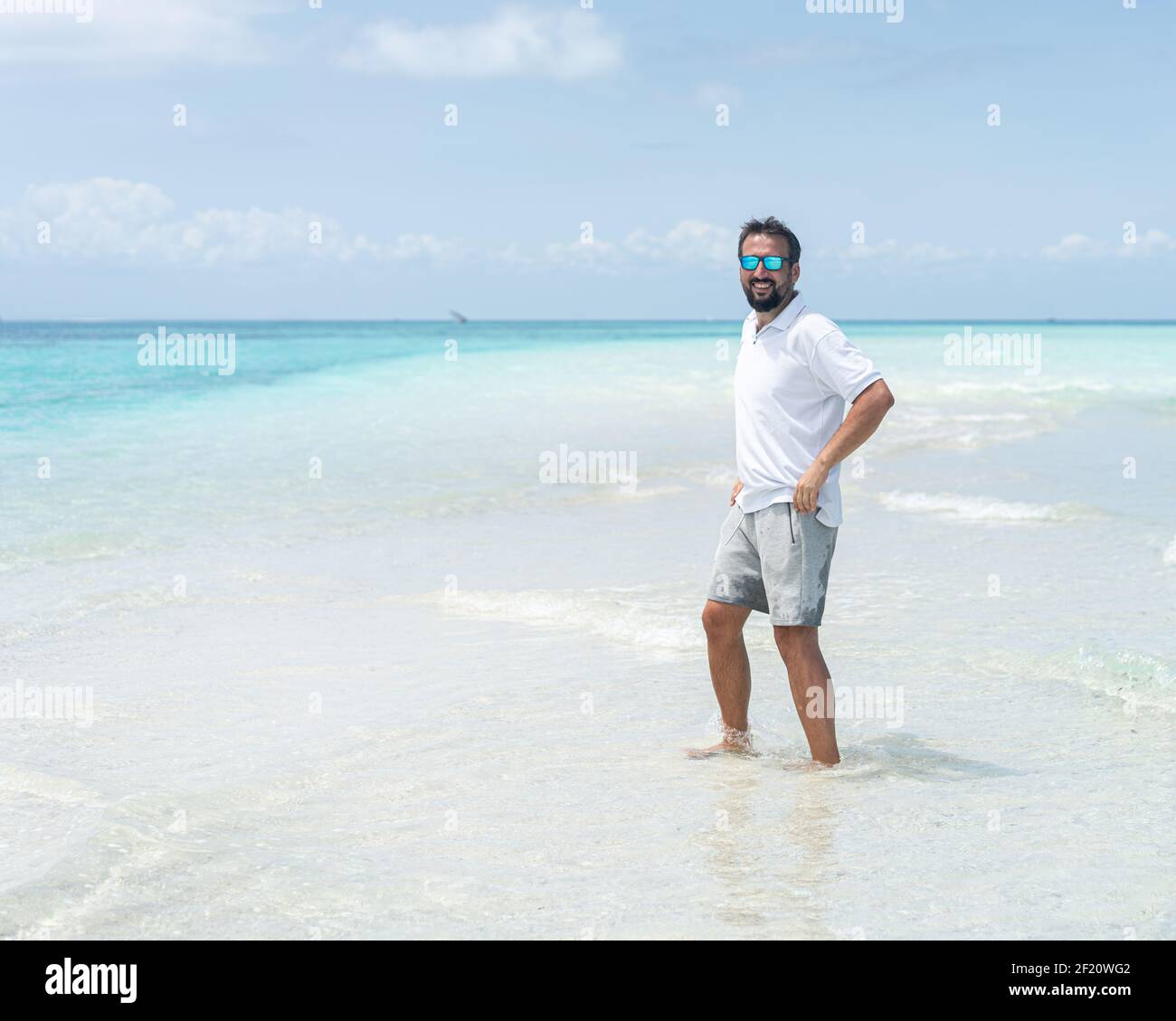 Un uomo si gode di una bellissima spiaggia tropicale Foto Stock