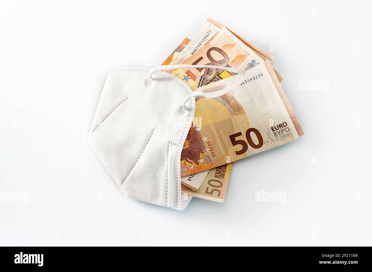 ffp2 maschera medica di protezione contro il coronavirus riempito di banconote in euro, concetto di aumento dei costi nell'assistenza sanitaria o di arricchimento per corruzione, Foto Stock