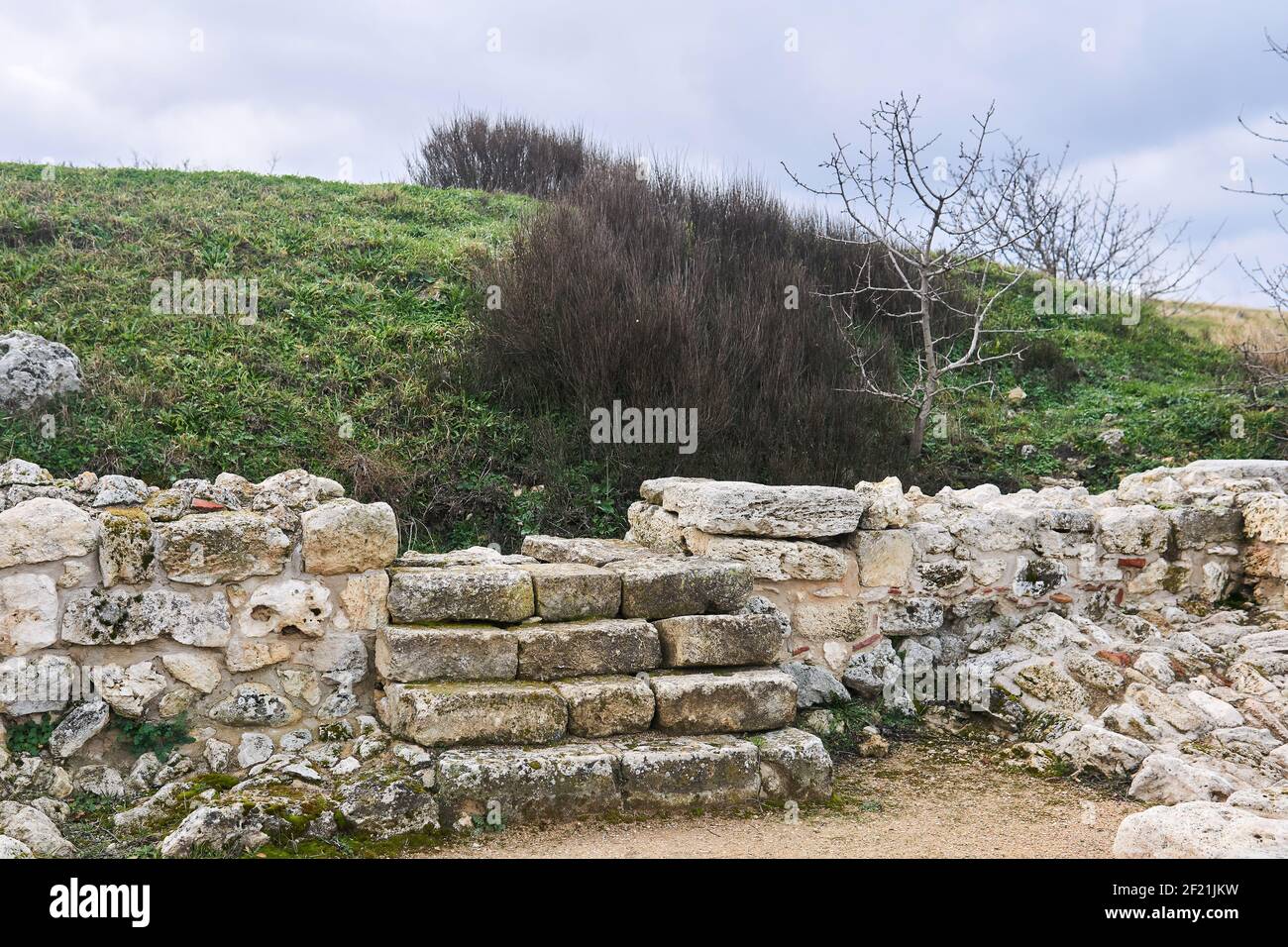 scalini di pietra nelle rovine di un'antica casa piombo ad una parte non scavata di esso sotto la collina Foto Stock