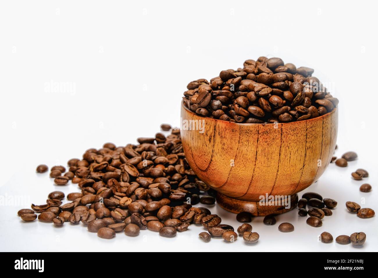 Chicchi di caffè. Chicchi di caffè arrosto in una ciotola di bambù. Isolato su sfondo bianco. Foto Stock