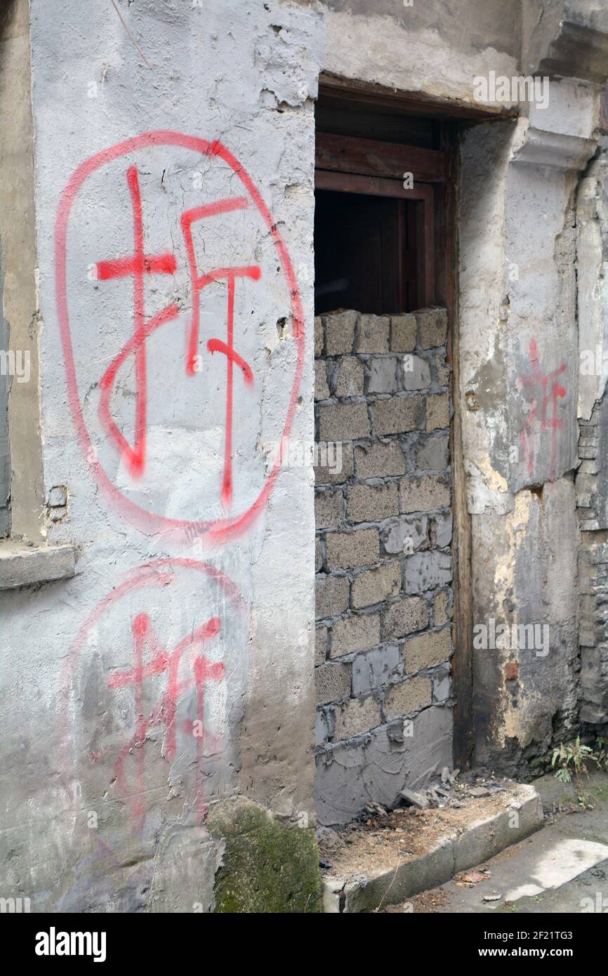 Dipinto di rosso carattere cinese 'cai', che significa demolizione. Le case sono mirate, residenti spostati fuori, porte bricked in su poi la demolizione inizia a un certo punto. Foto Stock