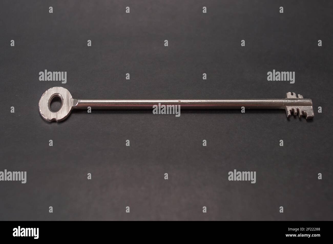 Una chiave di sicurezza, una chiave di sicurezza in un design extra lungo. Lo sfondo è nero e c'è molto spazio per il testo Foto Stock