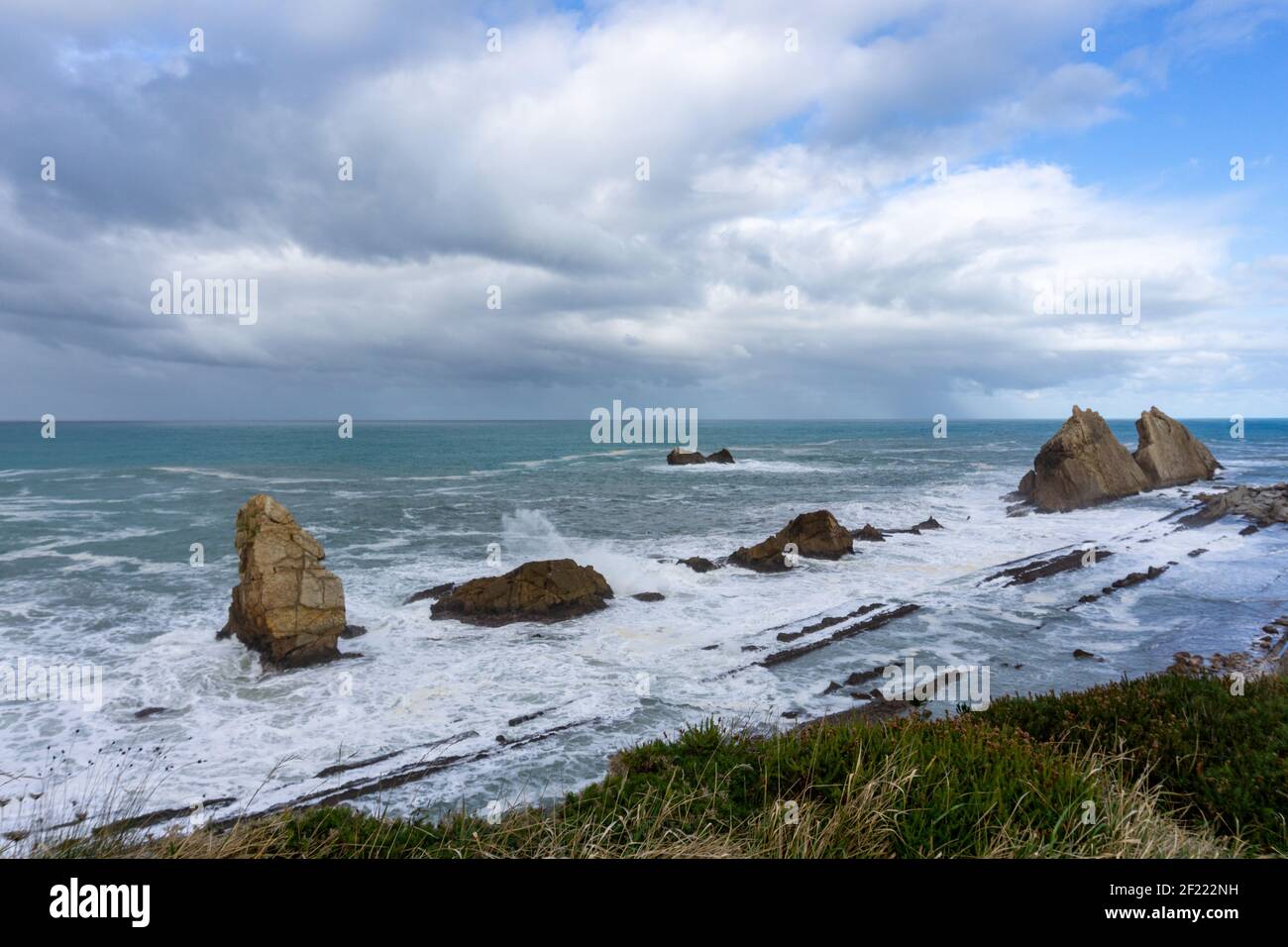 Costa rocciosa e selvaggia con onde tempestose che colpiscono la riva Foto Stock