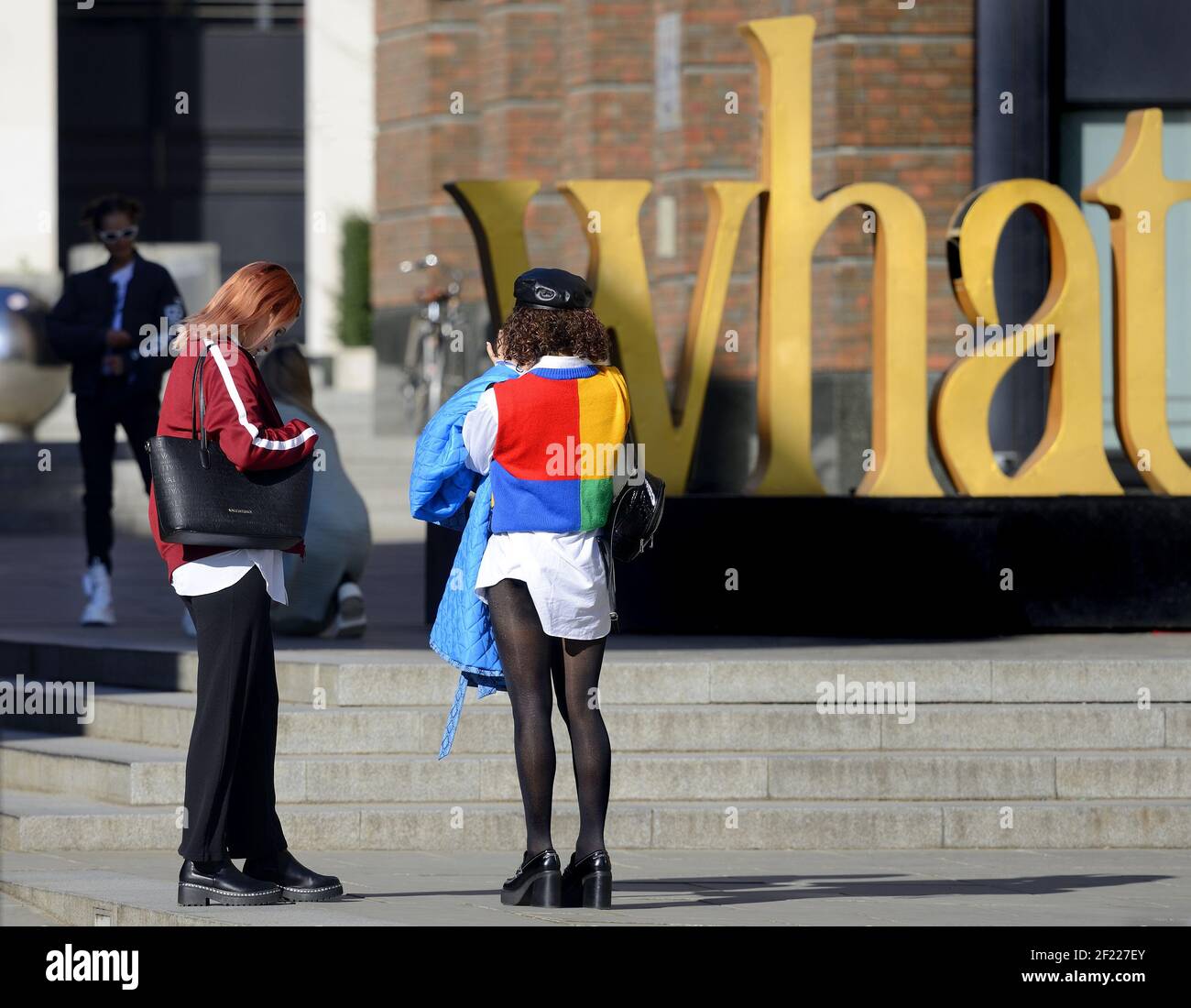 Londra, Inghilterra, Regno Unito. Giovane donna dai vestiti luminosi che fotografa un'installazione d'arte vicino alla Cattedrale di San Paolo Foto Stock