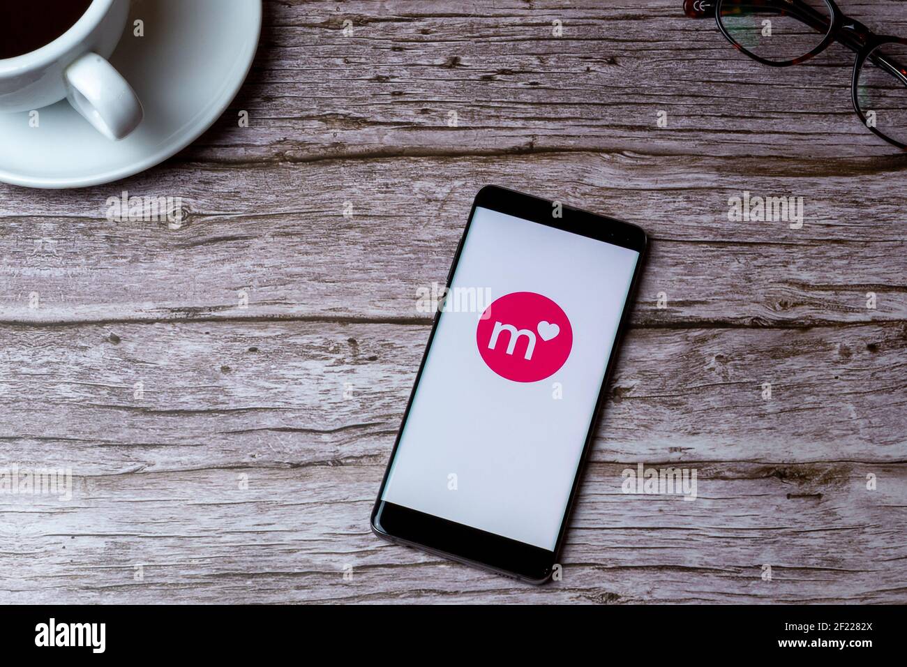Un telefono cellulare o un telefono cellulare posato su un legno Tavolo o scrivania con l'app Match dating aperta Foto Stock
