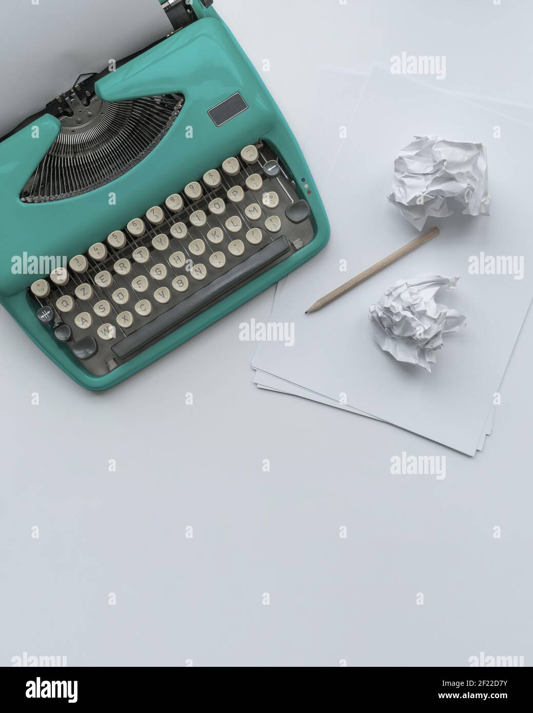Una macchina da scrivere vintage con fogli di carta, stencil e palle di carta. Foto Stock