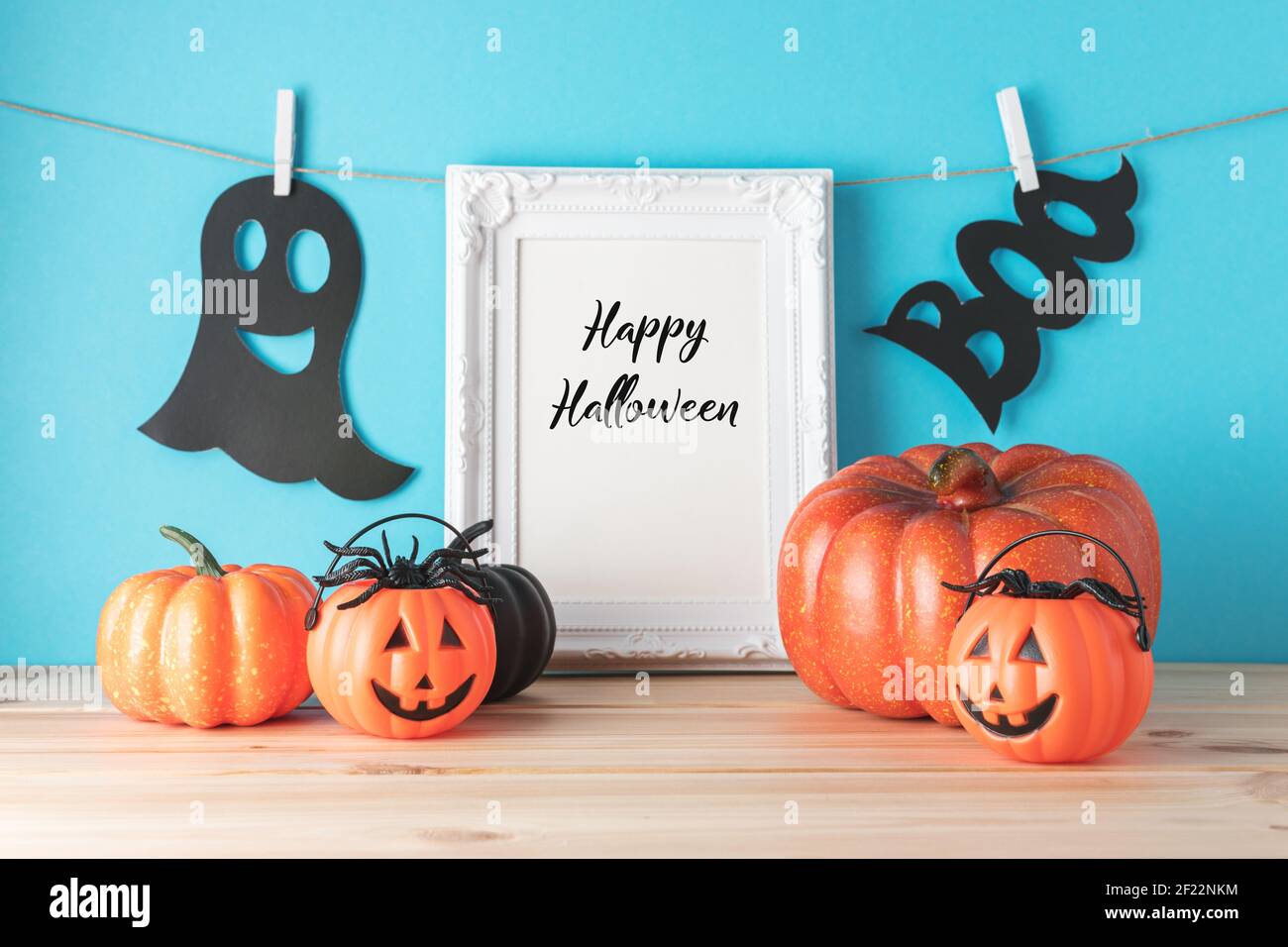 Concetto di vacanza con decorazione della zucca di Halloween e cornice fotografica su tavolo di legno. Concetto minimale creativo di Halloween. Foto Stock