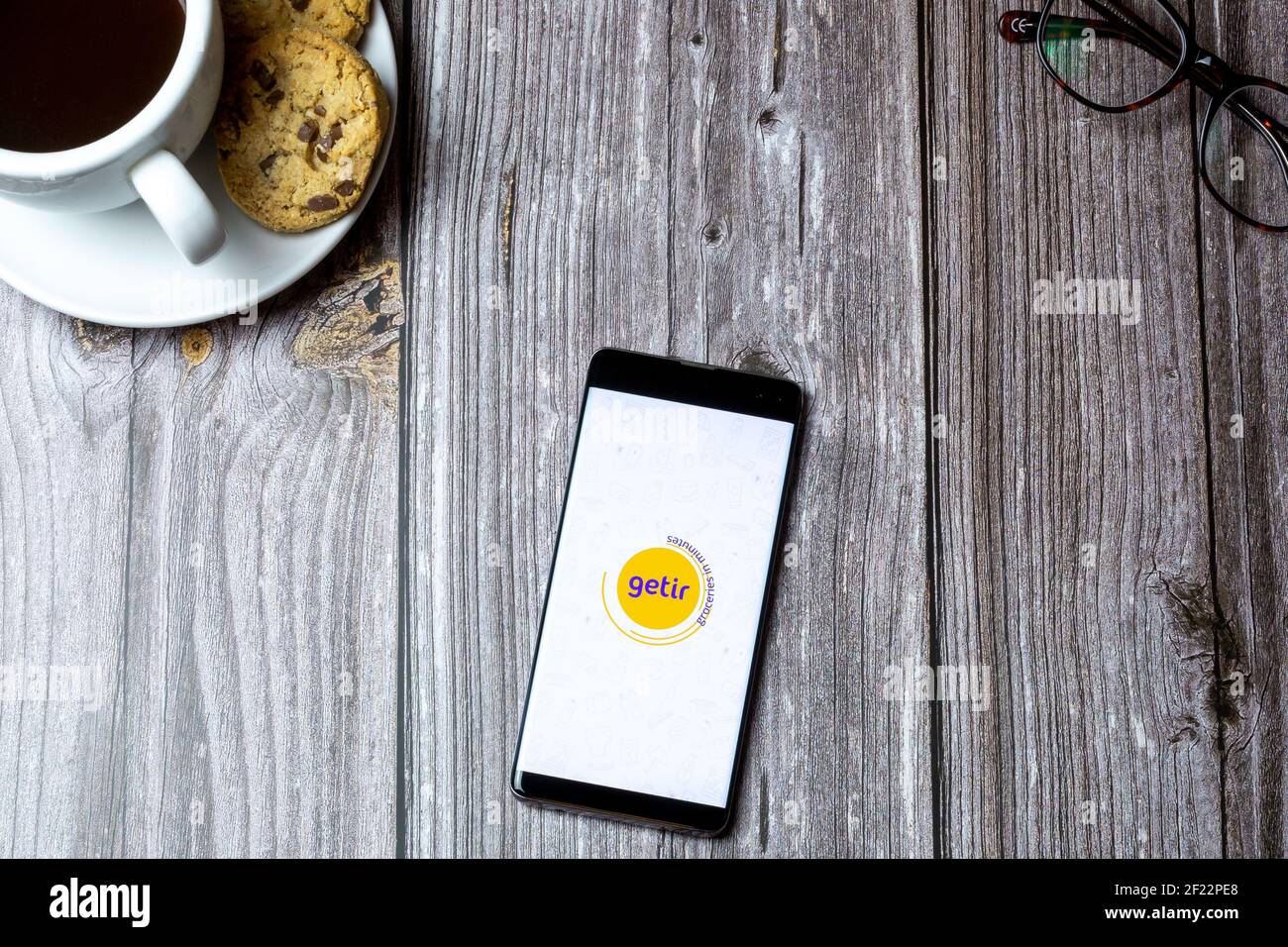 Un telefono cellulare o un telefono cellulare posato su un legno Tabella con l'app Getir aperta sullo schermo Foto Stock