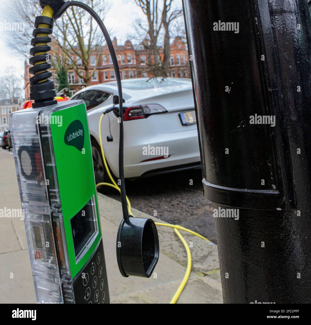 L'auto elettrica Tesla viene caricata presso un punto di ricarica Ubiviricity a Kensington, Londra Foto Stock