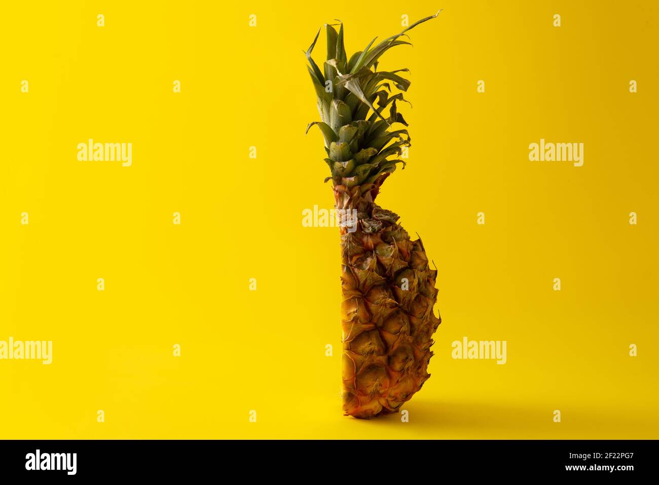 Ananas a fette su sfondo giallo. CopySpace Foto Stock
