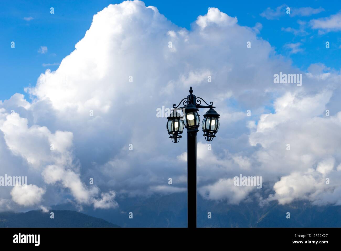 torcia elettrica contro un paesaggio di montagna e nuvole Foto Stock