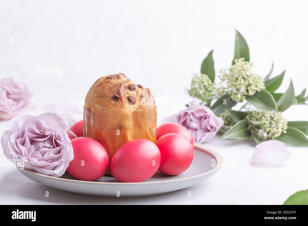 Mini panettone, uova rosa tinte naturali e fiori sul tavolo delle feste, brunch di Pasqua, festa Foto Stock