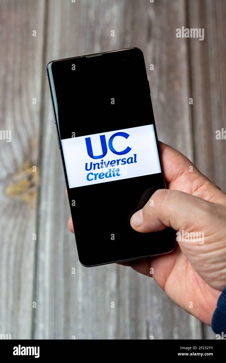 Un telefono cellulare o un telefono cellulare in attesa in un Mano con il logo di credito universale aperto sullo schermo Foto Stock