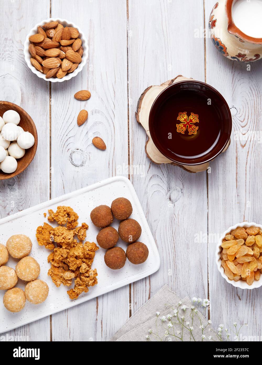 Cibo nazionale kazako come zhent, kurt, latte, palle dolci da formaggio casolare, noci e uvetta durante il festival Nauryz su sfondo di legno bianco. Foto Stock