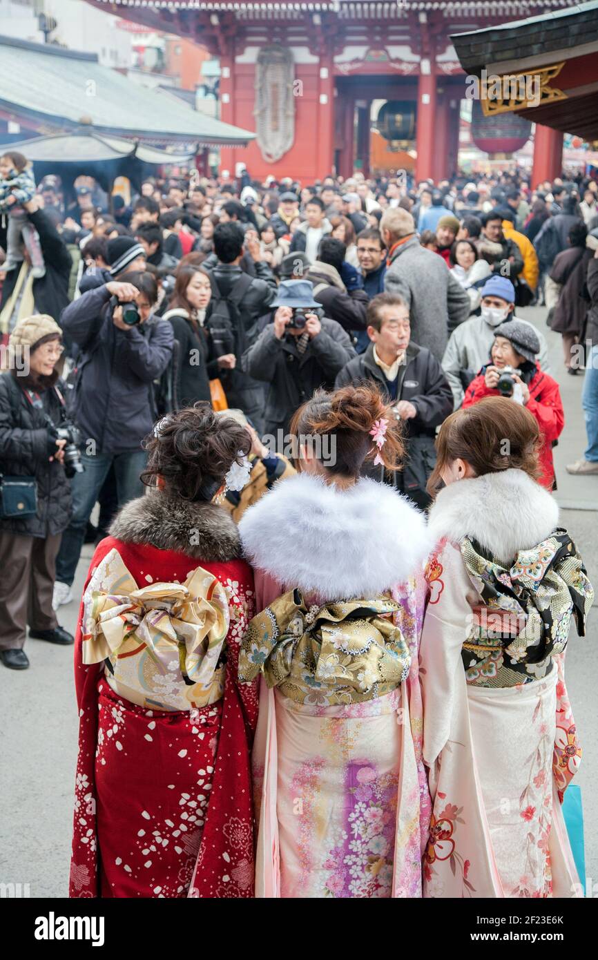 Tre donne giapponesi vestite in kimonos in arrivo di Age Day (Seijin no hi) che sono fotografate da membri del pubblico, Asakusa, Tokyo, Giappone Foto Stock