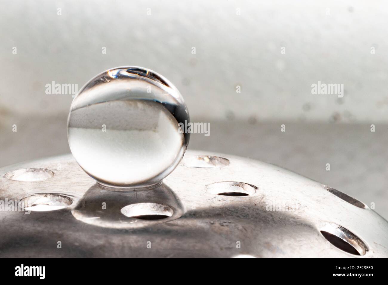 La sfera unica in equilibrio su supporto metallico in bianco sfondo Foto Stock