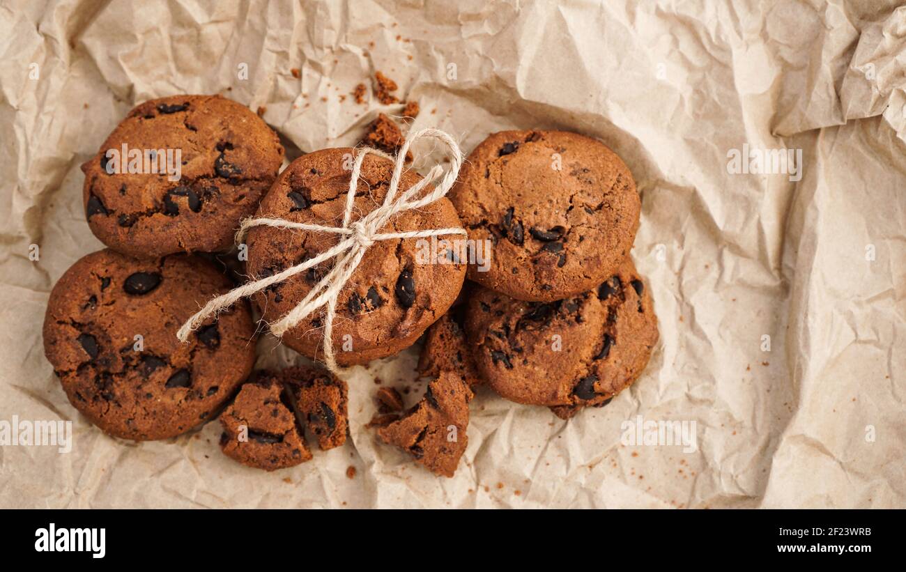 Vista su alcuni biscotti fatti a mano al cioccolato con scaglie di cioccolato sulla cottura carta Foto Stock