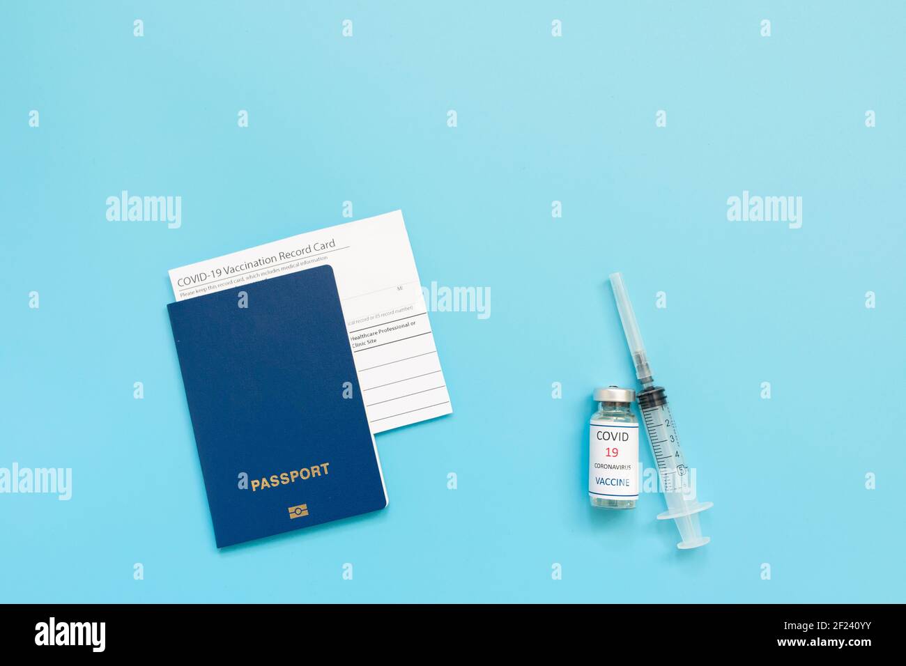 Scheda di vaccinazione, passaporto, flaconcino con vaccino covid-19 siringa e maschera su sfondo blu, primo piano, spazio per la copia. Passaporto dell'immunità, senza rischi Foto Stock