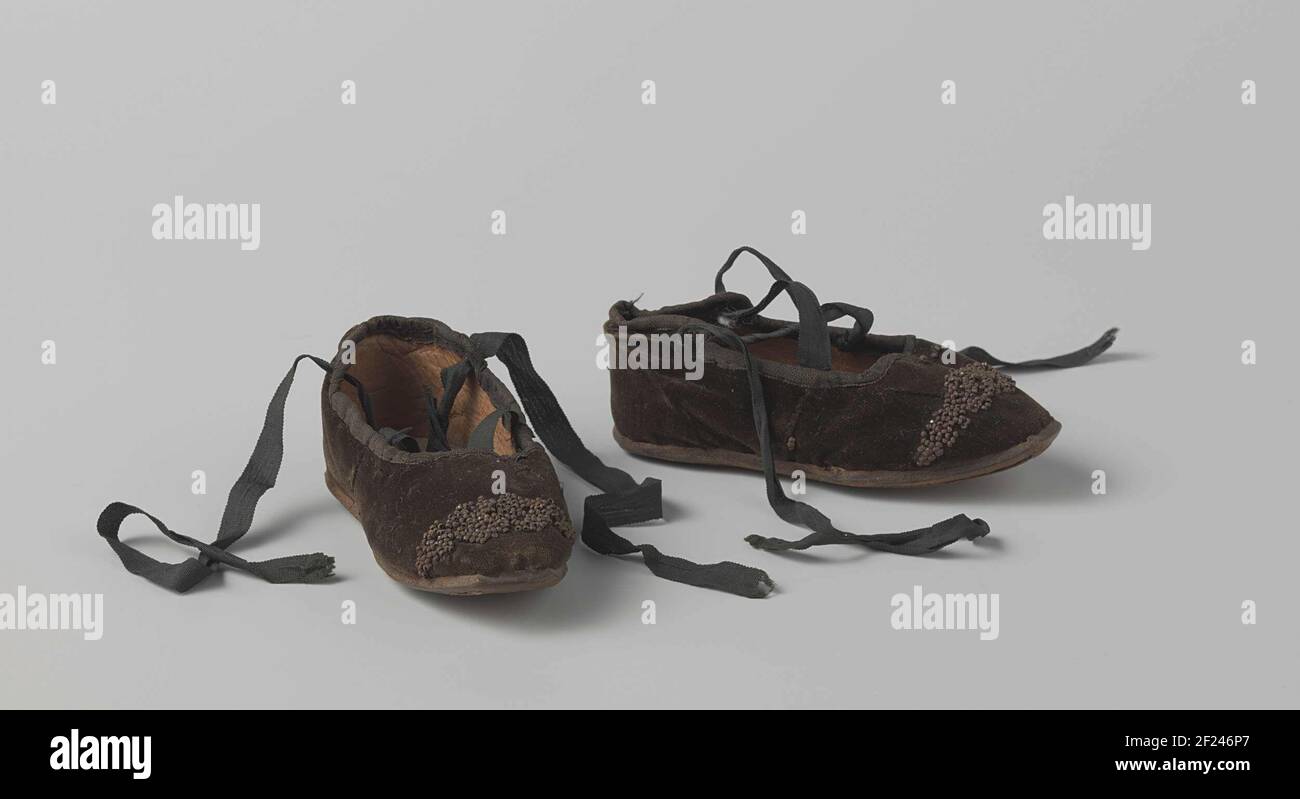 Scarpe Schoen van zwart fluweel.Black in velluto. Uguale sinistra e destra, crocifissi, suola in pelle, decorata con perline metalliche (arrugginite). Forse una scarpa per bambini o una scarpa per bambole. Foto Stock