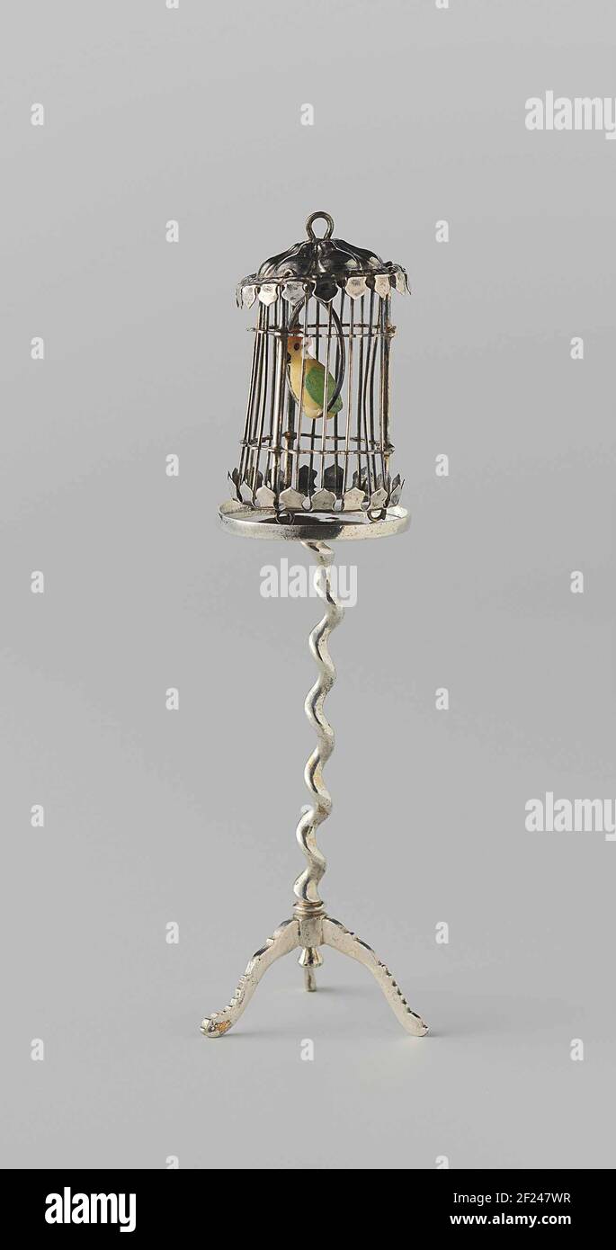 Vogelkooi Met papegaai.gabbia di uccello cilindrica rotonda. I bordi superiore e inferiore sono come una lampada. C'è un uccello colorato in un anello nella gabbia. La gabbia è in piedi su tre anelli e sulla parte superiore della gabbia è presente un anello di trasporto. La gabbia è segnata: Una testa di cinghiale e il numero 13 (livelli ungheresi). La gabbia si trova su un gueridone (BK-NM-11177-155-B). Foto Stock