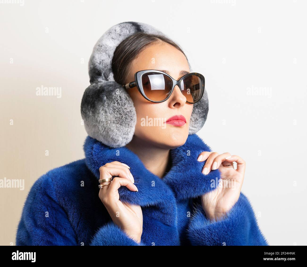 Cuffie invernali in pelliccia su donna con rivestimento in pelliccia blu. Concetto di moda minimale. Foto Stock