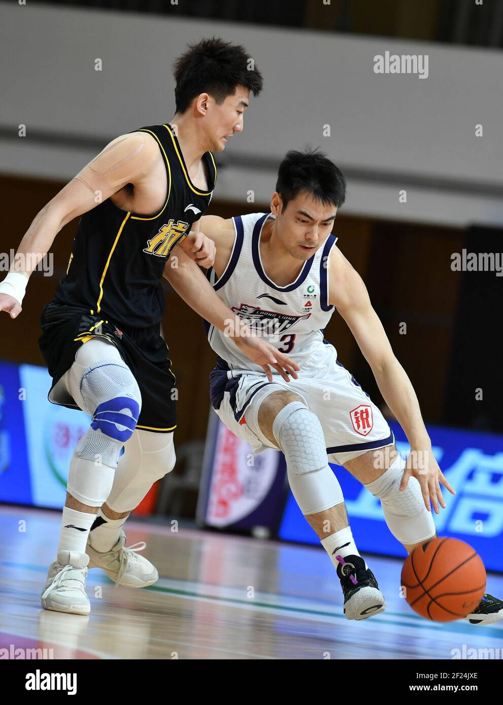 Zhuji, provincia cinese di Zhejiang. 10 marzo 2021. Sun Minghui (L) di Zhejiang Lions compete contro Jia Mingru di Guangzhou Loong Lions durante la 44° partita tra i Lions di Zhejiang e i Lions di Guangzhou Loong nella stagione 2020-2021 della Chinese Basketball Association (CBA) a Zhuji, provincia di Zhejiang, 10 marzo 2021. Credit: HU Huhu/Xinhua/Alamy Live News Foto Stock