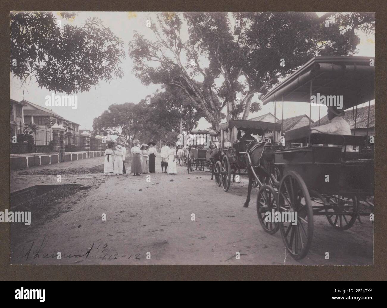 A Saint-Laurent-du-Maroni in Frans Guyana.membri della famiglia Gonggrijp e amici camminando attraverso una strada a Saint-Laurent-du-Maroni in Frans Guyana, al confine con il Suriname. Durante una visita al villaggio da parte della famiglia Gonggrijp il 18-19 dicembre 1912. Parte di un gruppo di undici album blade con foto di famiglia della famiglia Gonggrijp in Suriname, ca. 1912. Foto Stock