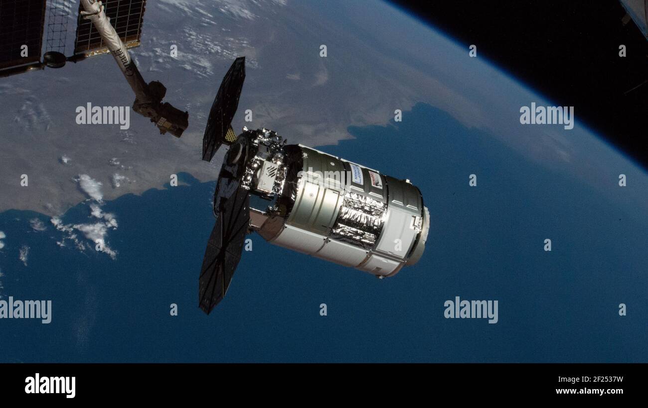 La navicella spaziale Northrop Grumman Cygnus con i distinti pannelli solari a forma di cembalo è appiccata dal CanadaArm2 per l'attracco alla Stazione spaziale Internazionale 22 febbraio 2021 a Earth Orbit. Foto Stock