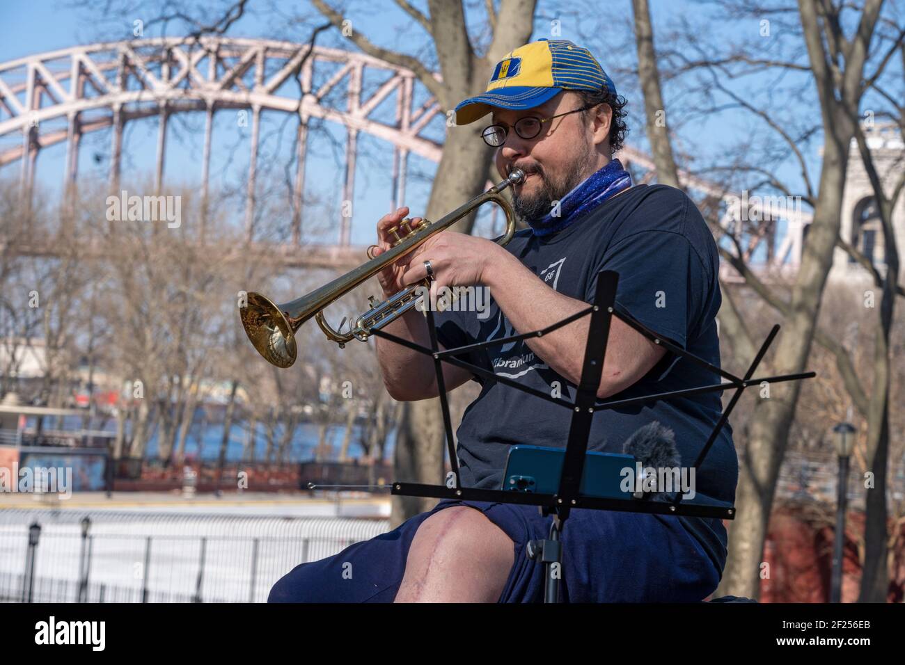 NEW YORK, NEW YORK - 9 MARZO: Matt Lavelle suona una tromba in un pomeriggio caldo ad Astoria Park il 9 marzo 2021 a New York City. Giorni successivi di sn Foto Stock