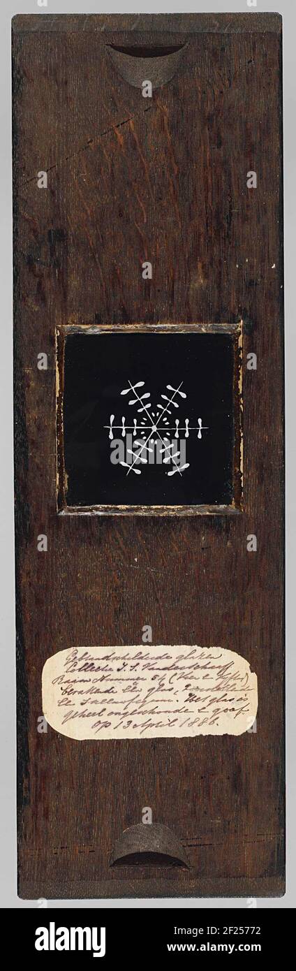 Sneeuwster.lastra di vetro quadrata con supporto in legno. Stella di neve in una superficie nera: Sei linee dal centro con pezzi trasversali a forma di stiramento su di essa. Foto Stock