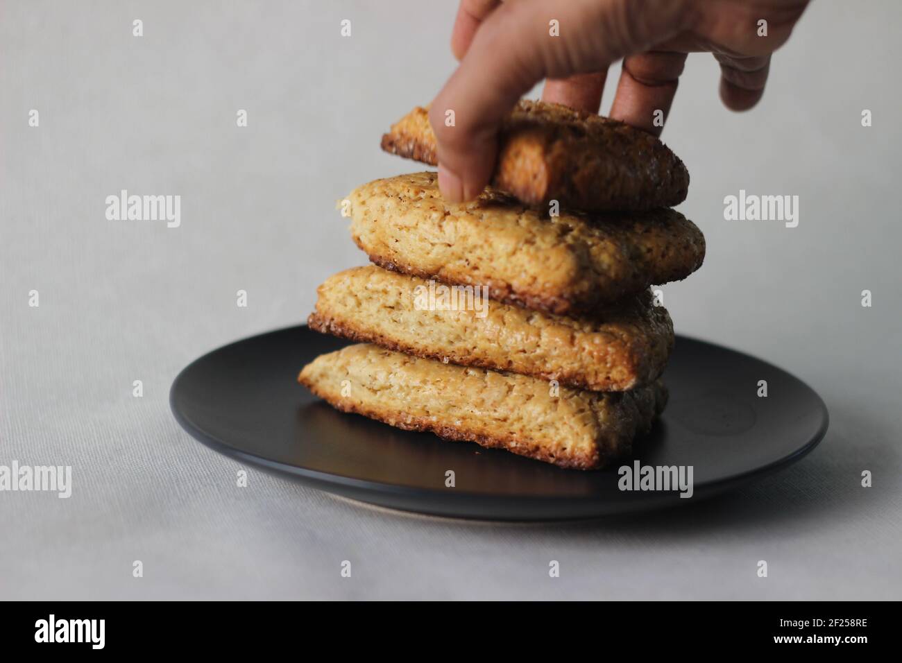 Focaccine di latticello dolci semplici cotte in casa, quattro delle quali accatastate su un piatto grigio. Scatto su sfondo bianco Foto Stock