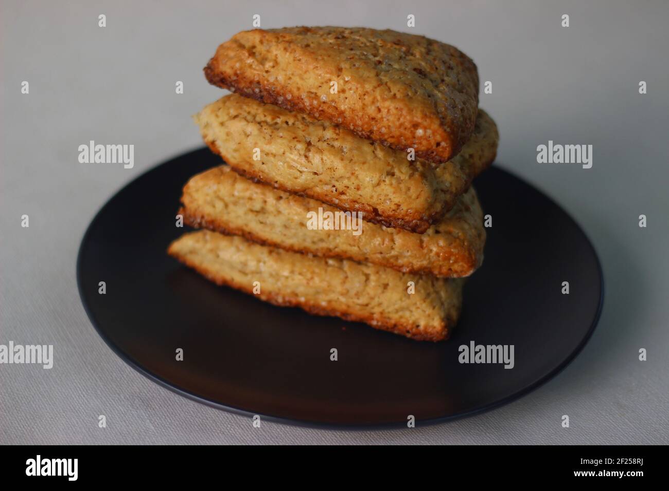 Focaccine di latticello dolci semplici cotte in casa, quattro delle quali accatastate su un piatto grigio. Scatto su sfondo bianco Foto Stock