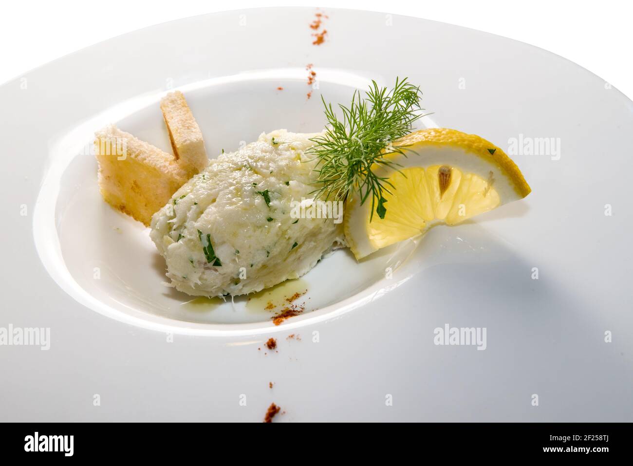 Merluzzo cremoso, tipico antipasto veneziano, chiamato 'baccalà mantecato' in un piatto bianco con fetta di limone e pane tostato Foto Stock