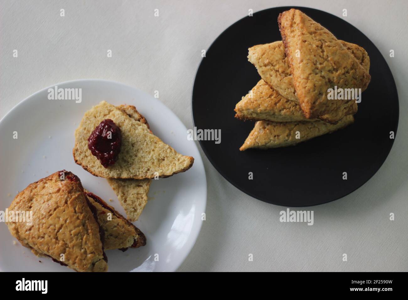 Focaccine di latticello dolci semplici cotte in casa, quattro delle quali accatastate su un piatto grigio. Scatto su sfondo bianco Foto Stock