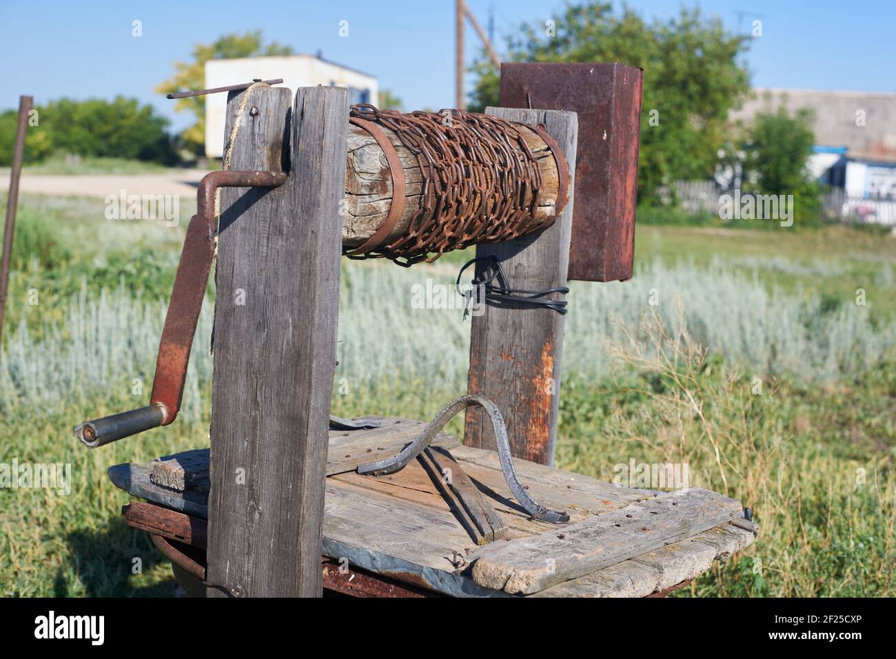 Moderno rustico legno estrazione acqua bene Rusty catena Foto Stock