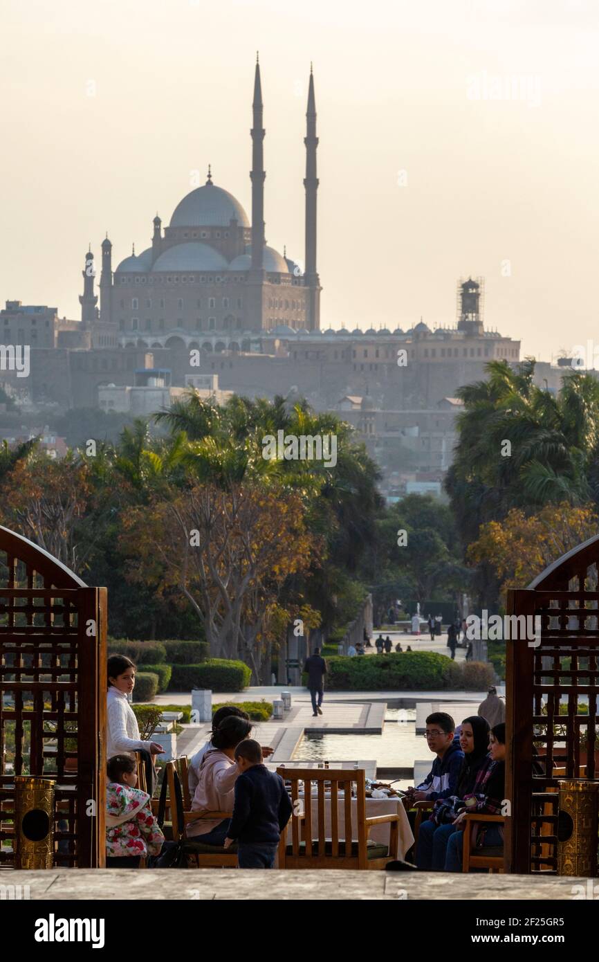 Le persone che cenano in un ristorante al Azhar Park con la Cittadella del Cairo in background, Salah Salem St, El-DARB El-Ahmar, il Cairo, Egitto Foto Stock