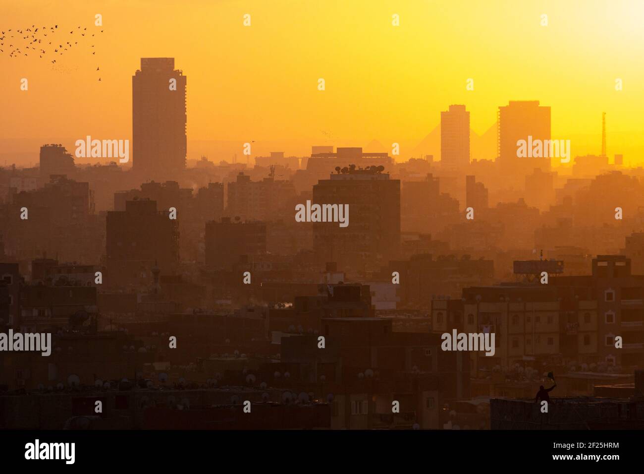 Paesaggio urbano del Cairo al tramonto con piramidi visibili sullo sfondo, come si vede dal Parco al Azhar, Salah Salem St, El-DARB El-Ahmar, Cairo, Egitto Foto Stock