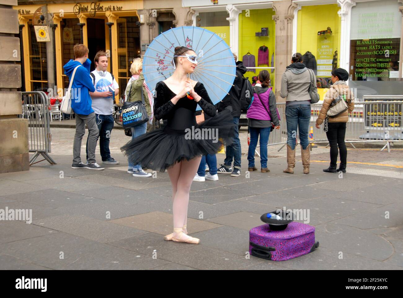 Giovane ballerina al Festival della frangia di Edimburgo, con ombrellone e cappello per contributi (con bottiglia d'acqua in esso) Edimburgo, Scozia Foto Stock