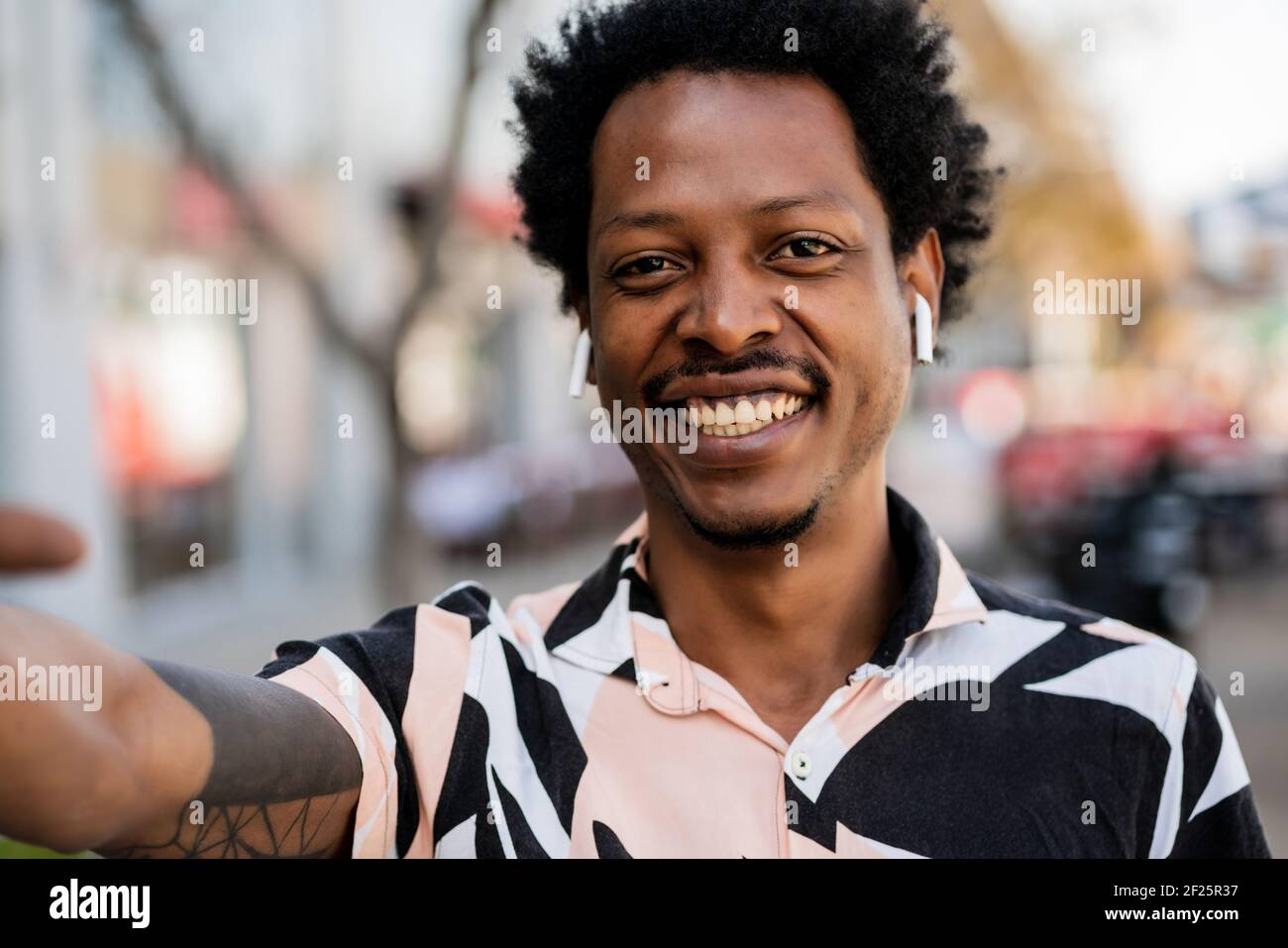 Ritratto di uomo afro che prende un selfie all'aperto. Foto Stock