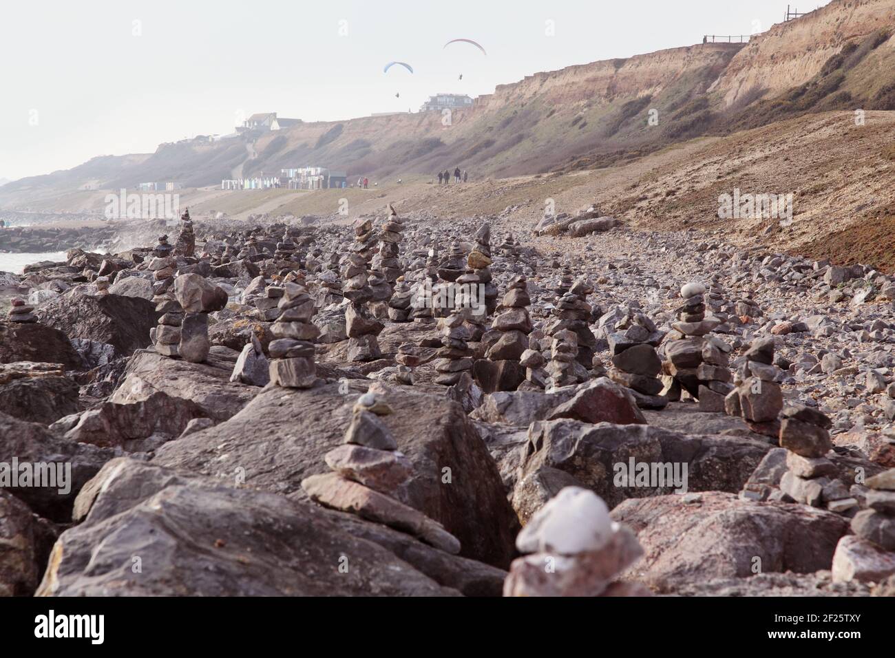 Spiaggia costa con centinaia di pietre equilibranti o rocce bilanciate impilate / impilate come cairns dal pubblico a Barton on sul mare durante la crisi Covid. Foto Stock